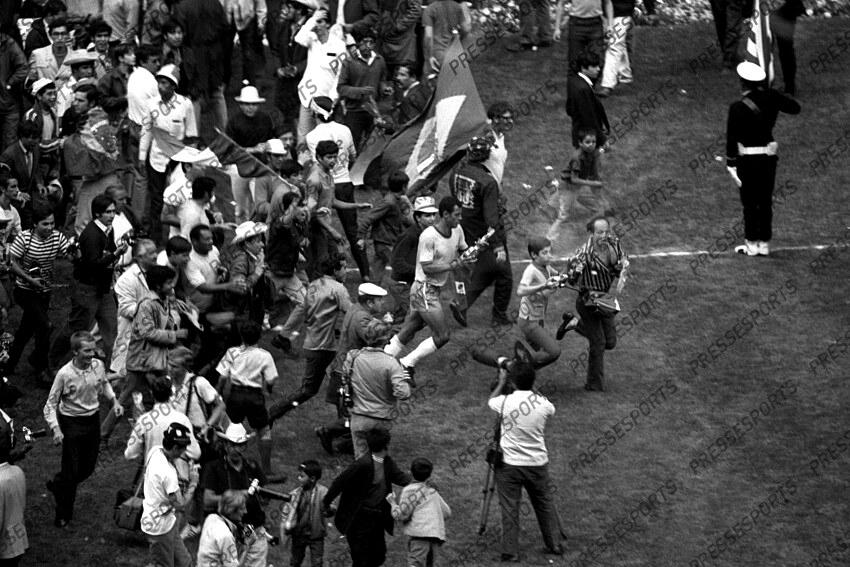 21 June 1970 - FIFA World Cup Final - Brazil v Italy - Carlos Alberto of Brazil does a lap of honour with the trophy followed by fans desperate to get near him. 