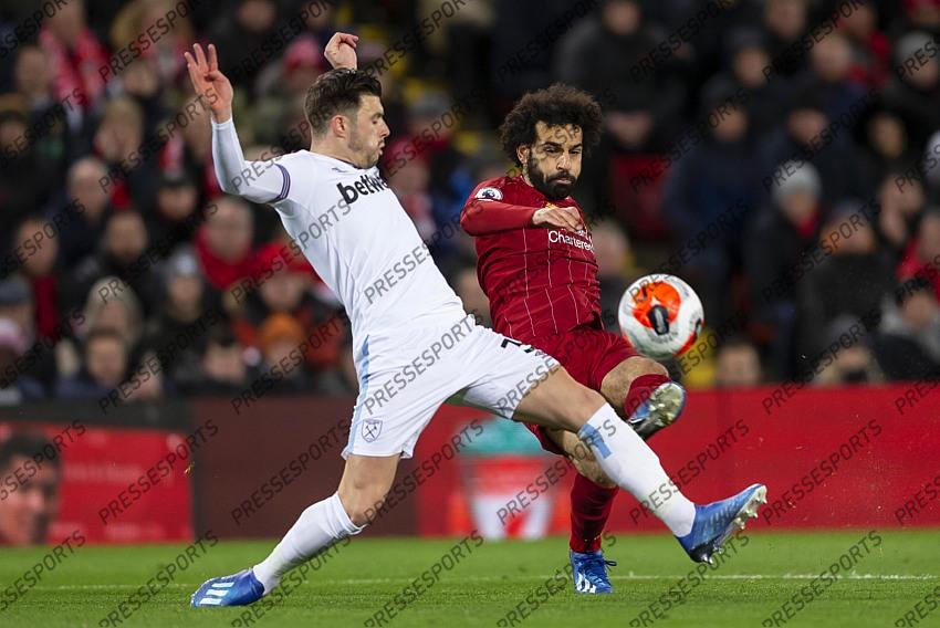 24 February 2020, Liverpool - Premier League Football - Liverpool v West Ham United. Aaron Cresswell of West Ham United tries to block a shot by Mohamed Salah of Liverpool (photo by Daniel Chesterton) 