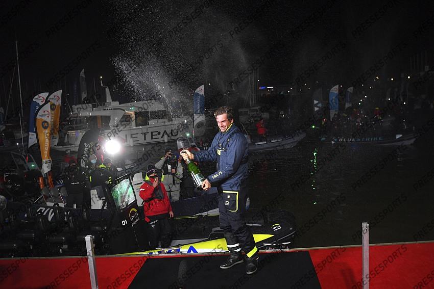 French yachtman Charlie Dalin celebrates with a bottle of champagne after crossing first the finish line of the Vendee Globe solo around-the-world sailing race, in Les Sables-d'Olonne, western France, Wednesday, Jan.27, 2021. The final winner of the race will be decided Thursday as some rival were given a time compensation. (Loic Venance, Pool via AP) 