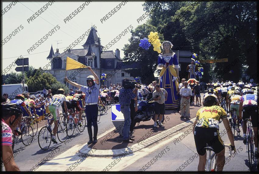 Un gendarme assure la securite des coureurs en signalant un ilot directionnel a l aide d un drapeau jaune. 
