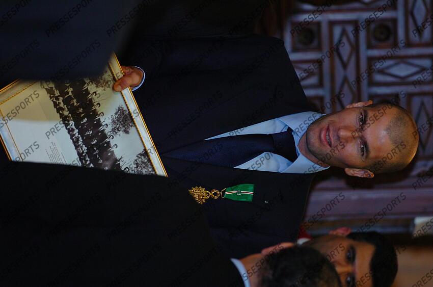zidane (zinedine) MAGAZINE ZIDANE EN ALGERIE L'(14/12/2006) recevant la médaille de l'Athir équivalent algérien de l'ordre national du mérite et tenant la photo de la première équipe du F.L.N. en 1958 