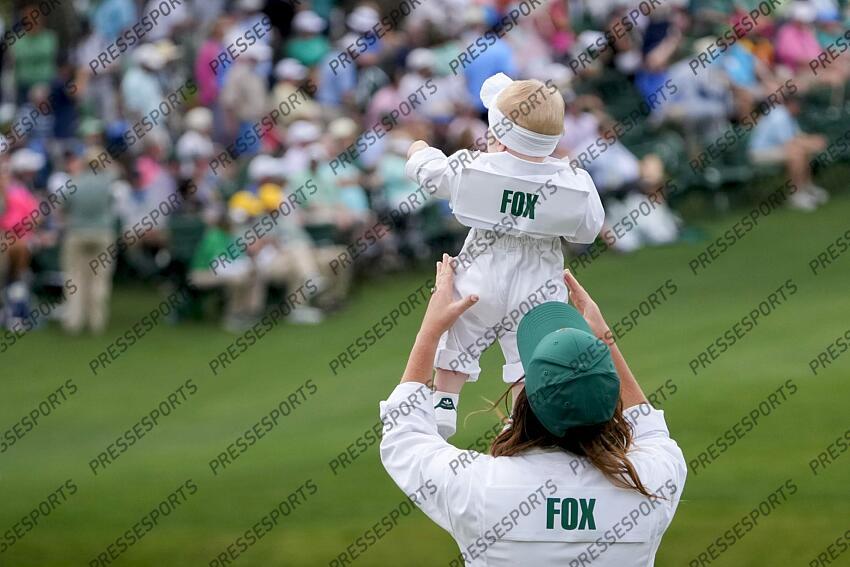 Apr 10, 2024; Augusta, Georgia, USA; Anneke Ryff lifts her daughter, Margot Fox during the Par 3 Contest at Augusta National Golf Club. Mandatory Credit: Michael Madrid-USA TODAY Network concours par 3 PGA: Masters Tournament - Par 3 Contest 