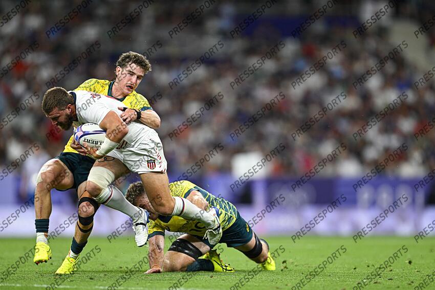 Steve Tomasin is tackled by Ben Dowling and Nick Malouf during the Olympic Games Rugby Seven men’s match between USA v Australia at Stade de France in Saint-Denis near Paris, France on July 25, 2024. SOIREE 25 JUILLET 