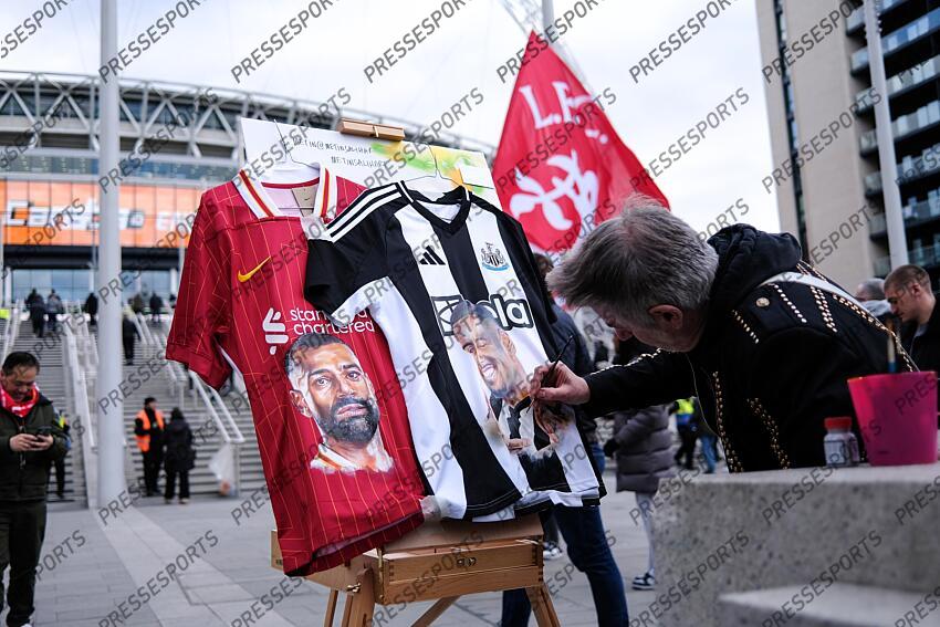 16 March 2025, London - Carabao Cup Final - Liverpool v Newcastle United - A man paints the faces on Mohamed Salah and Alexander Isak on football shirts - Photo: Jacques Feeney / Offside. FINALE LIVERPOOL-NEWCASTLE (1-2) 
