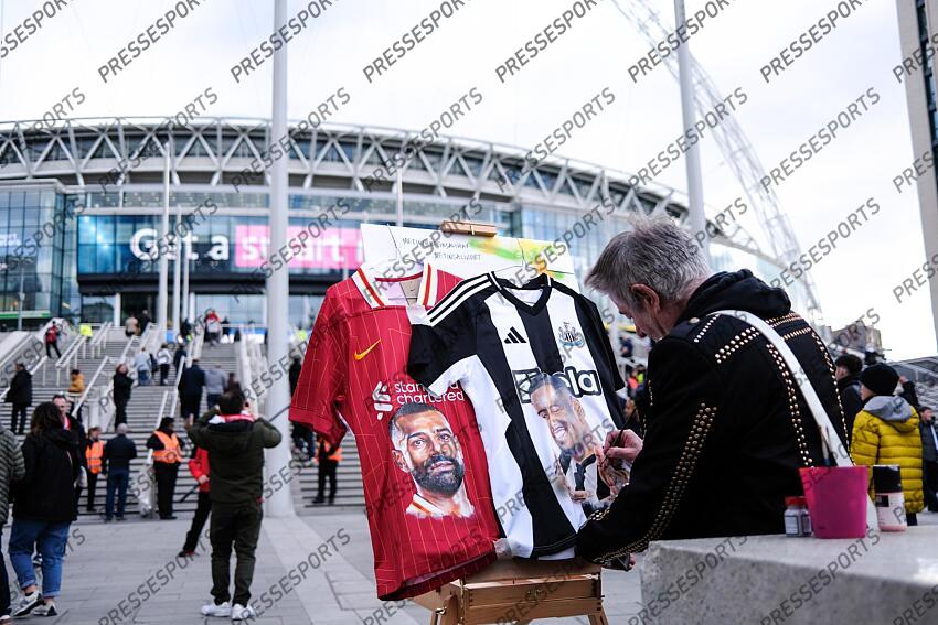 16 March 2025, London - Carabao Cup Final - Liverpool v Newcastle United - A man paints the faces on Mohamed Salah and Alexander Isak on football shirts - Photo: Jacques Feeney / Offside. FINALE LIVERPOOL-NEWCASTLE (1-2) 