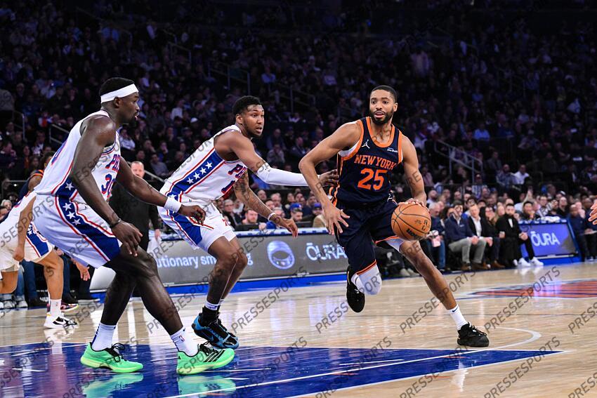 Apr 1, 2025; New York, New York, USA; New York Knicks forward Mikal Bridges (25) drives to the basket while being defended by Philadelphia 76ers forward Justin Edwards (19) and Philadelphia 76ers center Adem Bona (30) during the first half at Madison Square Garden. Mandatory Credit: John Jones-Imagn Images NBA: Philadelphia 76ers at New York Knicks 