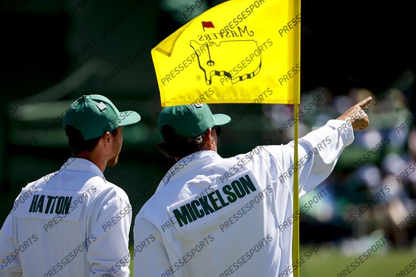 Apr 8, 2025; Augusta, Georgia, USA; Hugo Dobson, caddie for Tyrrell Hatton, and Jon Yarbrough, caddie for Phil Mickelson, talk on the no. 15 green during a practice round for the Masters Tournament at Augusta National Golf Club. Mandatory Credit: Peter Casey-Imagn Images PGA: Masters Tournament - Practice Round 