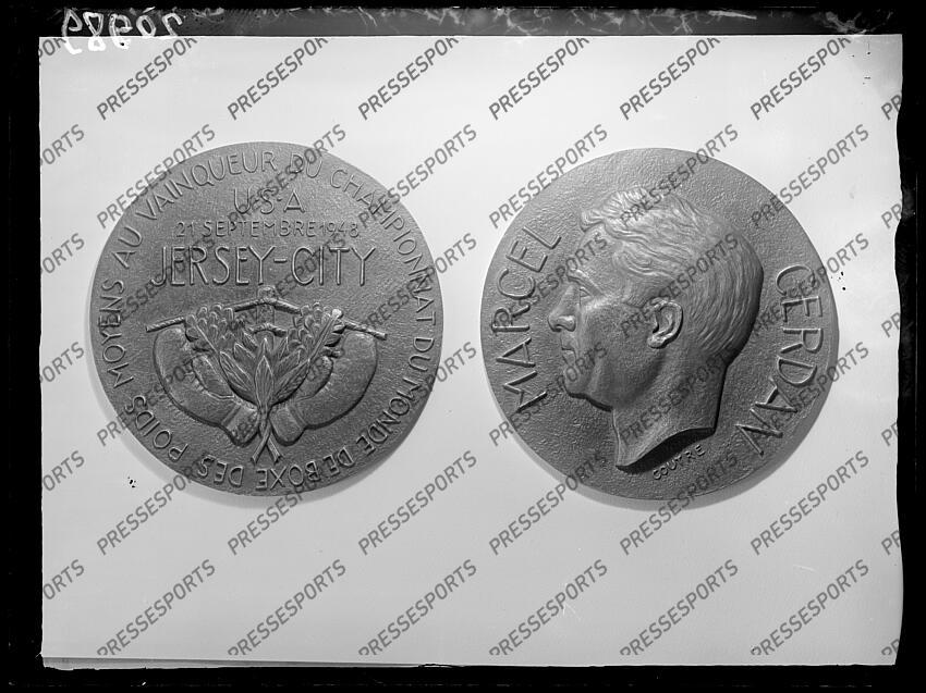 Médaille à l'effigie de cerdan (marcel) - (fra) - "Au vainqueur du championnat du monde de boxe des poids moyens USA 21 septembre 1948 Jersey City" le 21 septembre 1948, le boxeur Marcel Cerdan parvenait à battre Tony Zale, décrochant ainsi le titre mondial des poids moyens. MAGAZINE CERDAN fonds n/b Date et lieu de prise de vue inconnus. 