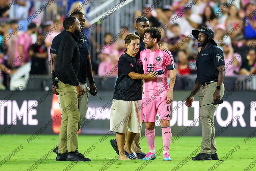 May 3, 2025; Fort Lauderdale, Florida, USA; a fan runs onto the field to meet Inter Miami CF forward Lionel Messi (10) during a match against the New York Red Bulls in the second half at Chase Stadium. Mandatory Credit: Nathan Ray Seebeck-Imagn Images MLS: New York Red Bulls at Inter Miami CF 
