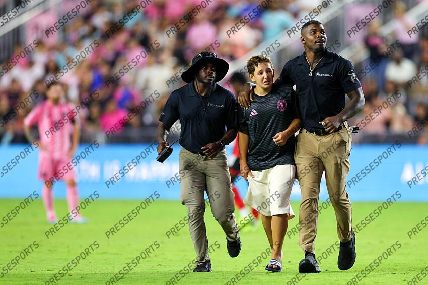 May 3, 2025; Fort Lauderdale, Florida, USA; a fan runs onto the field to meet Inter Miami CF forward Lionel Messi (10) during a match against the New York Red Bulls in the second half at Chase Stadium. Mandatory Credit: Nathan Ray Seebeck-Imagn Images MLS: New York Red Bulls at Inter Miami CF 